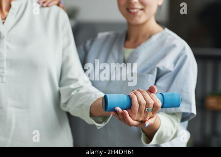 Close up of senior woman training with weights in retirement home, copy space Stock Photo