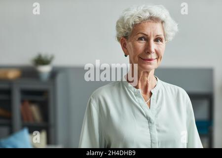 Portrait of smiling senior woman looking at camera in retirement home, copy space Stock Photo