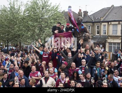 West Ham United fans chant from The Bobby Moore statue in Barking Road outside the Boleyn Ground, east London, ahead of the last ever Barclays Premier League match played in Upton Park before the Hammers move to the Olympic Stadium.  Stock Photo