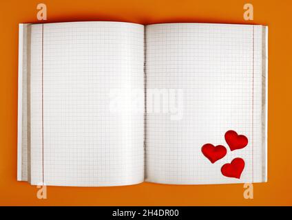 Empty Opened Notepad with Red Hearts on the Orange Paper Background closeu Stock Photo