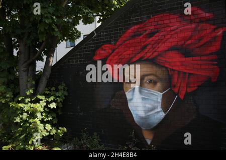 A mural in Ladywell, south east London, by street artist Lionel Stanhope depicting a painting by Flemish master Jan van Eyck wearing a protective face mask, as the UK continues in lockdown to help curb the spread of the coronavirus. Picture date: Friday May 8, 2020. Stock Photo