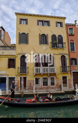 Gondolier with two young women tourists in Venice, Italy Stock Photo