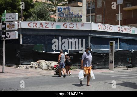 Tourists walk past a run-down leisure centre in the English district of Levante in Benidorm, a seaside resort on the eastern coast of Spain, which remains almost empty following the UK government’s quarantine to all tourists that travel from Spain because of its high levels of COVID-19 cases. Picture date: Thursday July 30, 2020. Stock Photo