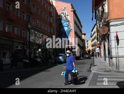 A worker wearing face covering walks past a large artwork in central Madrid, as the capital registers more than a third of the 716,481 coronavirus cases diagnosed in Spain. Picture date: Monday September 28, 2020. Stock Photo