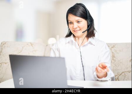 Business Video Conference. businesswoman using laptop talk to colleagues in video call for smart working from home at living room. woman entrepreneur Stock Photo