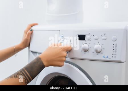 Woman operating washing machine at home Stock Photo - Alamy