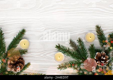 Seasonal wooden Christmas border, decoration with spruce, cones and candles. Copy space. Flat lay. Stock Photo