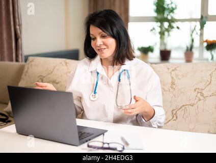 doctor online. woman consults a patient, makes a video call from a webcam on a laptop. videoconference remote computer application virtual meeting. Stock Photo