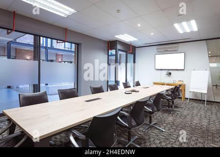 Interior of empty conference room with tv, desk and chairs in modern office Stock Photo