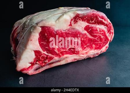 Raw Bone-in Standing Prime Rib Roast: Uncooked rib roast tied with kitchen twine Stock Photo