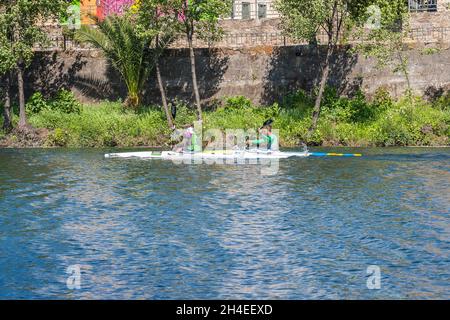 PLASENCIA, SPAIN - Apr 24, 2021: Two young men practice canoeing riding in his canoe navigating the Jerte river, Spain Stock Photo