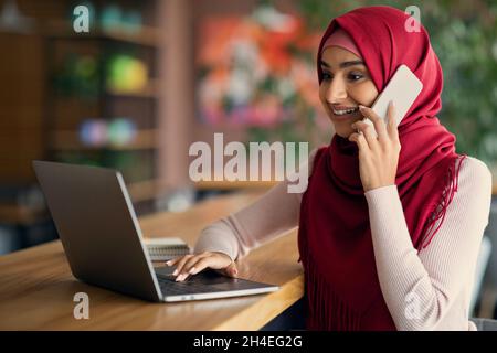 Muslim young woman independent contractor working at cafe Stock Photo