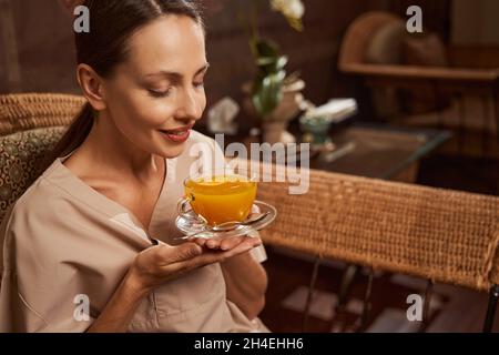 Spa salon client smelling aroma of herbal beverage Stock Photo