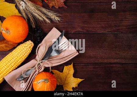 Thanksgiving cutlery setting. Festive table decor on a wooden background. Place for text. Stock Photo