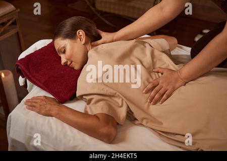 Massotherapist hands pressing on patient trigger points Stock Photo