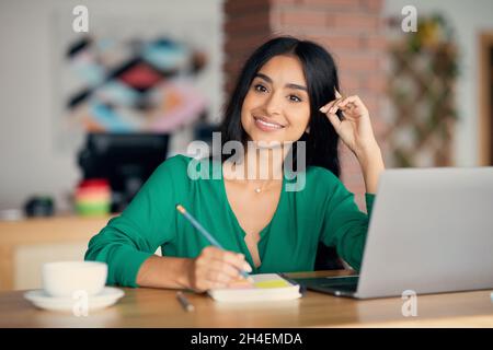 Beautiful indian woman freelancer working at cafe Stock Photo