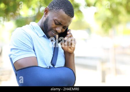 Disabled black man calling on mobile phone complaining in a park Stock Photo