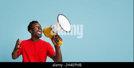 Emotional Young Black Guy Making Announcement With Megaphone In Hands Stock Photo