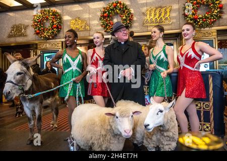 New York, USA. 1st Nov, 2021. Rockettes laugh with New York City's Archbishop Timothy Dolan after he blessed the animals that will appear in a living Nativity scene at the Radio Citiy Music Hall Christmas Spectacular in New York City. The show returns after having been cancelled last year during the pandemic lockdown. Credit: Enrique Shore/Alamy Live News Stock Photo