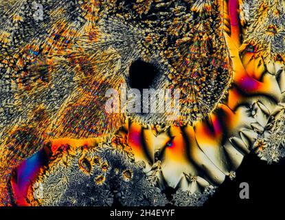 Extreme macro photograph of Vitamin C crystals forming abstract modern art patterns, when illuminated with polarized light, under a microscope Stock Photo