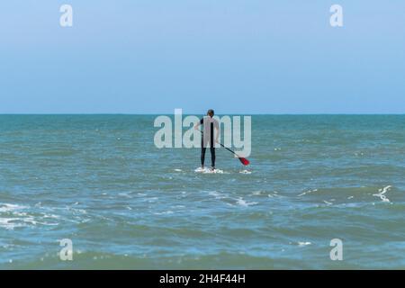 Man practicing Stand up paddle in the sea