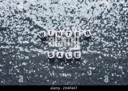 Winter sale words on silver sequined fabric textile background. Festive Christmas sale party glitter fashion texture web banner Stock Photo