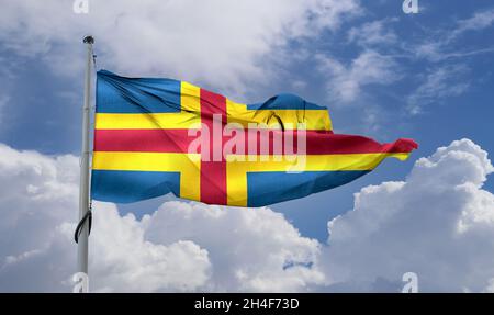 Flag of Aland Islands at a flagpole moving in the wind against the sky Stock Photo