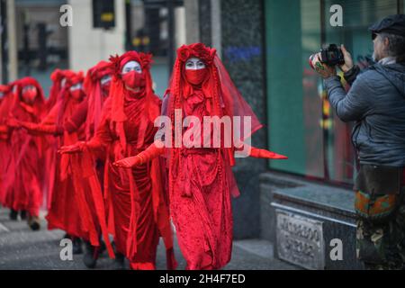 Glasgow Scotland, UK November 02 2021. Extinction Rebellion red robed protesters travel in a procession through the city to the COP 26 barricades behind which world leaders gather to discuss their response to climate change. credit sst/alamy live news Stock Photo