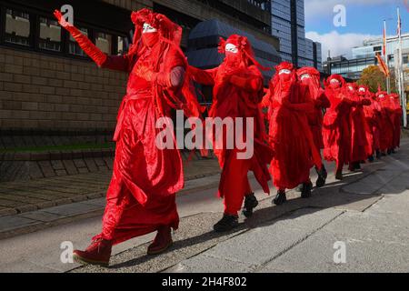 Glasgow Scotland, UK November 02 2021. Extinction Rebellion red robed protesters travel in a procession through the city to the COP 26 barricades behind which world leaders gather to discuss their response to climate change. credit sst/alamy live news Stock Photo