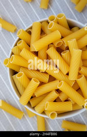 Dry Rigatoni Pasta in a gray Bowl, top view. Flat lay, overhead, from above. Stock Photo