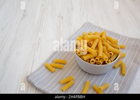 Dry Rigatoni Pasta in a gray Bowl, side view. Copy space. Stock Photo