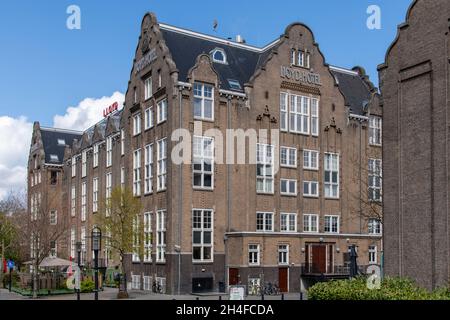 Amsterdam, The Netherlands-May 2021: Low angle view of the 1920's architectural building and monument that was a hotel for emigrants, then a prison Stock Photo