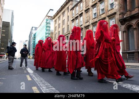Extinction rebellion (XR) protesters wearing red robes during a protest calling out the banks continued profits from and investment into fossil fuel projects and contribution to the suffering caused by the climate crisis outside J.P. Morgan bank offices during the COP26 UN Climate Change Conference in Glasgow, Scotland on November 2, 2021. World leaders meeting at the COP26 climate summit in Glasgow will issue a multibillion-dollar pledge to end deforestation by 2030 but that date is too distant for campaigners who want action sooner to save the planet lungs. Photo by Raphael Lafargue/ABACAPRE