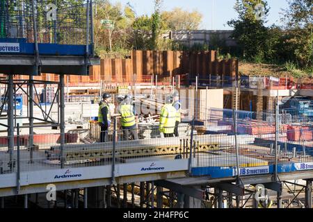 Construction workers inspect the building site on a sunny autumn day Greenwich London England UK Stock Photo