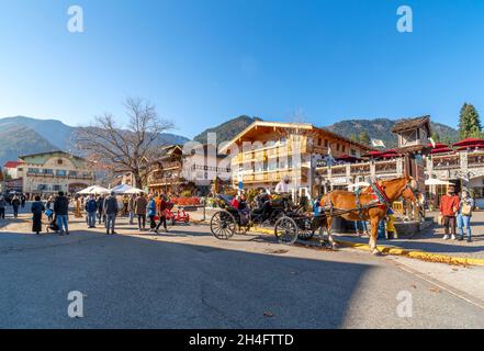 A horse carriage for hire with tourists in the colorful Bavarian themed village of Leavenworth. Stock Photo