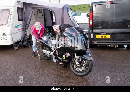 Drag race and partner tuning and prepping a drag racing bike in the outdoor pit at Santa Pod raceway and drag strip, October 2021 Stock Photo