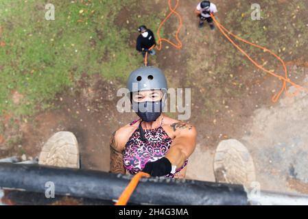 Woman wearing face mask and rappelling on the Lapa catwalk in Salvador, Bahia, Brazil. Stock Photo