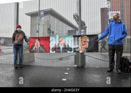 Glasgow, UK. 31st Oct, 2021. Protesters holding a banner with images of UK PM Boris Johnson depicting mock emotions, during the opening day of COP26 hosted in Glasgow from Saturday, 31st of October to 12th of November.COP26 is a convention by the United Nations to bring nations and countries from around the world to discuss how to deal with climate change and what can the nations do to try and minimise it or do to combat it. Credit: SOPA Images Limited/Alamy Live News Stock Photo