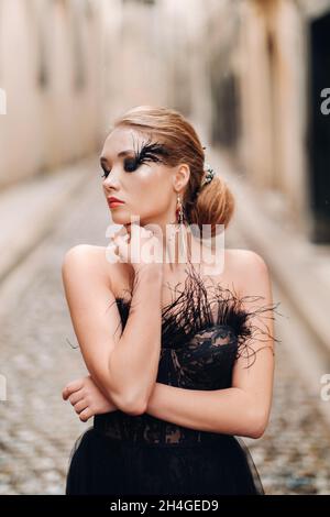A stylish bride in a black wedding dress poses in the ancient French city of Avignon. Model in a beautiful black dress. Photo shoot in Provence Stock Photo