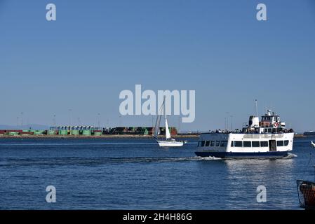 Los Angeles, CA USA - October 15, 2021: Excrsion boat and sailboat pass the containers stacked in the Port of Los Angeles during a shipping backlog Stock Photo