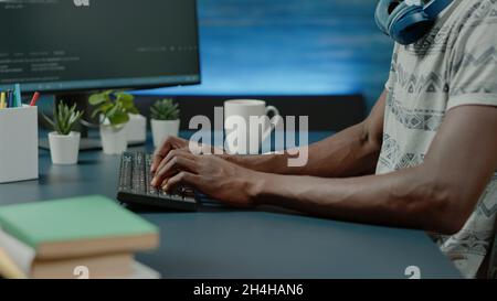 Close up of black hands coding server interface with binary codes on computer. African american coder programming website firewall for protection and software development. Web programmer Stock Photo