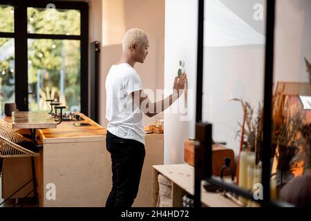Latin man choosing temperature on thermostat Stock Photo