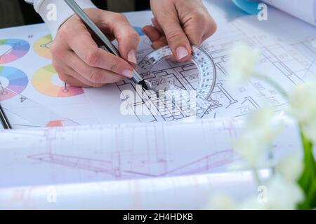 Hands use pencil with a protractor. Architectural Project drawings with tools. Architects workplace. Engineering Interior designer's working table. Wo Stock Photo