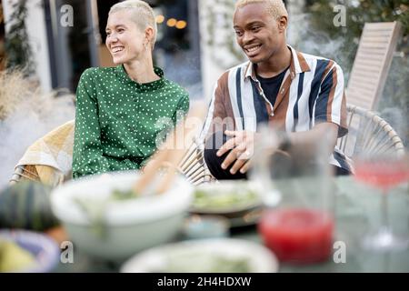 Multiracial couple having dinner at their backyard Stock Photo