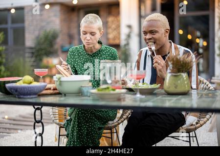 Multiracial couple having dinner at their backyard Stock Photo