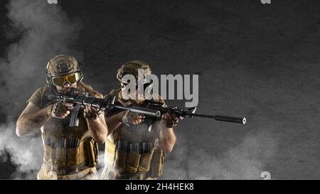 During a special operation, soldiers of the professional special forces are shrouded in smoke against the background of a dark concrete wall - they ai Stock Photo