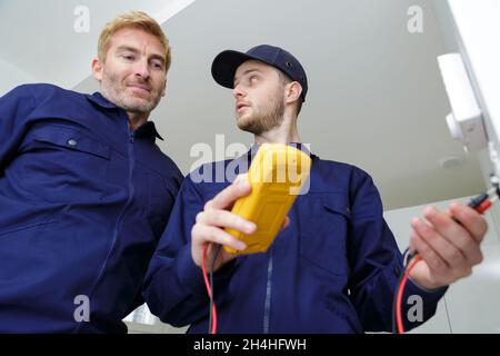 low angle view of trainee electrician using multimeter Stock Photo