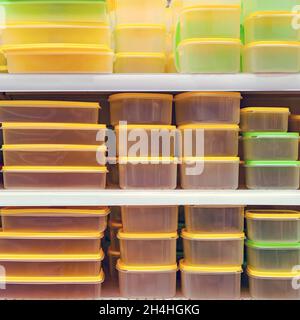 Plastic dishes and containers are sold on the shelves in the store, background Stock Photo