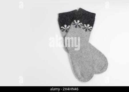Winter white with gray knitted socks with snowflakes. Top view, copy space for text Stock Photo