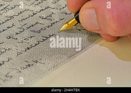 Close-up of a male hand ready to write with an elegant fountain pen. Handwriting - writing with a fountain pen. Antique handwriting Stock Photo